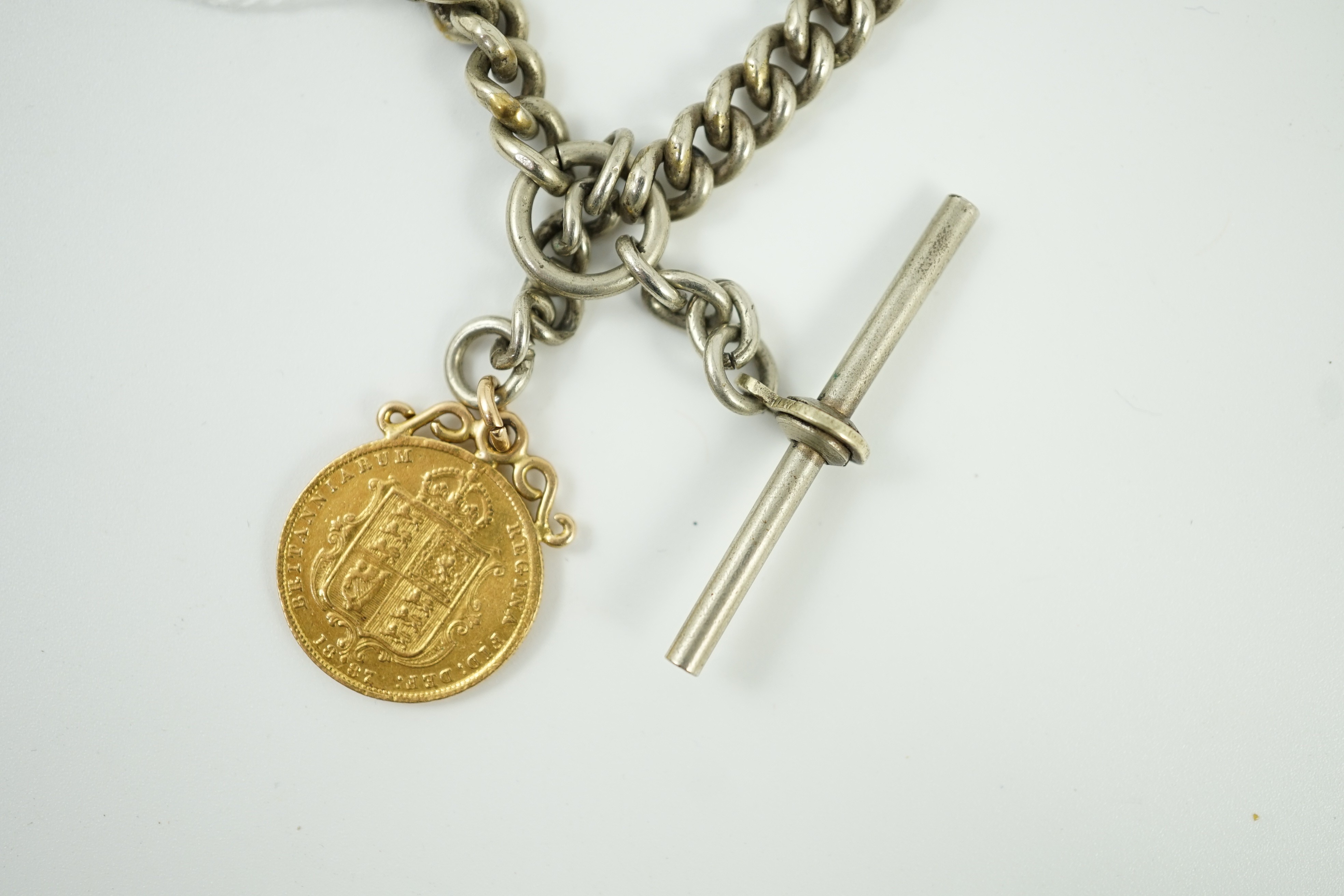 A Victorian 1887 gold half sovereign, on pendant mount and hung from a white metal albert.